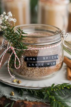 a jar filled with spices sitting on top of a table next to some cinnamon sticks