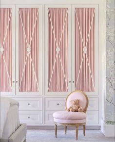 a teddy bear sitting on a pink chair in front of some closets with curtains