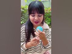 a woman holding a blue and white ball in her hands while wearing a striped shirt