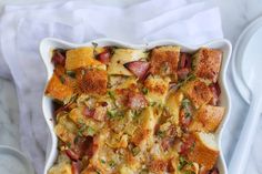 a casserole dish with meat and vegetables in it on a white table cloth