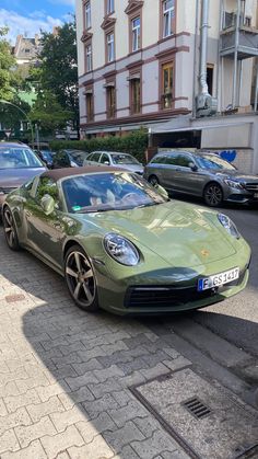 a green sports car is parked on the street