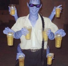 a man with blue hair and glasses holding two cups