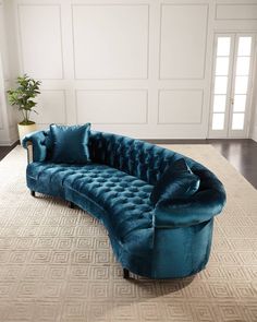 a blue couch sitting on top of a rug in a living room next to a doorway