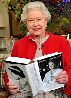 an older woman sitting down reading a book