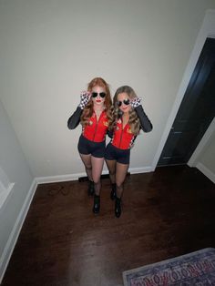 two women in red shirts and black shorts are standing next to each other with sunglasses on