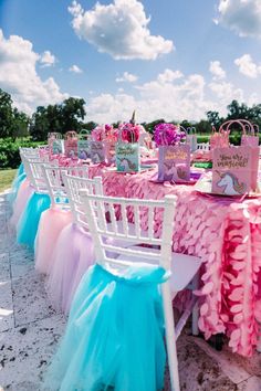 there is a table set up with pink and blue tulle skirts on the tables