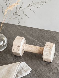 a pair of wooden dumbs sitting on top of a counter next to a vase