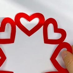 someone is holding up a cutout with hearts in the shape of a maple leaf