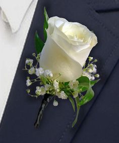 a white rose and baby's breath boutonniere on a blue suit