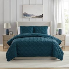 a bed in a bedroom with blue comforter and pillows