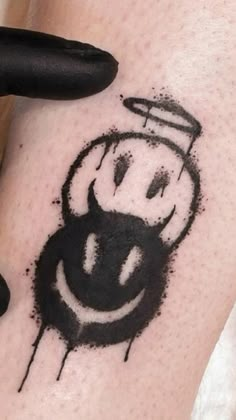 a person with a smiley face tattoo on their arm