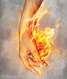 a hand holding a piece of meat on fire