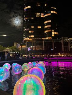 many glowing balls floating in the water at night