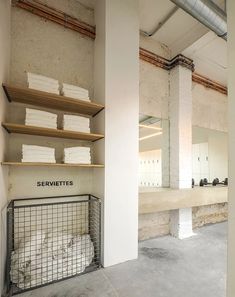 an empty room with shelves and towels on the wall