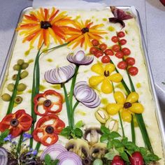 a sheet cake decorated with flowers and vegetables