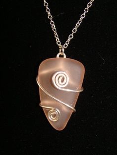 a piece of glass that is sitting on a chain with a pendant attached to it