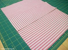 a cutting board with some red and white strips on it next to a green cutting mat