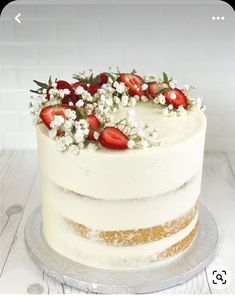 a white cake with strawberries and flowers on top