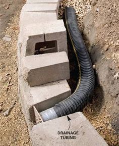 a drainage pipe is connected to the side of a concrete block wall with pipes running through it