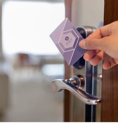 a person is opening a door with a purple card