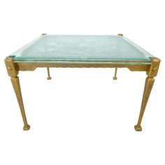 a glass and brass coffee table with two legs