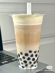 a drink sitting on top of a laptop computer