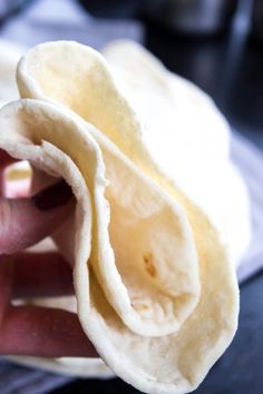 a person is holding some kind of tortilla in their hand and it looks like they are eating something out of the wrapper