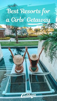 two women sitting at the edge of a pool with their arms in the air