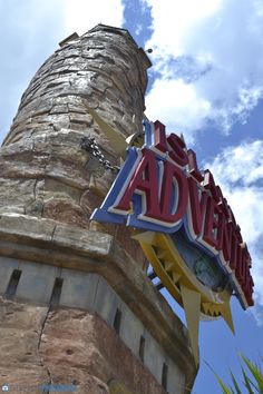 the sign for an adventure park on top of a tower