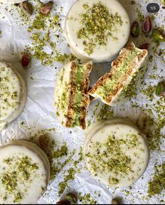 several pieces of cake sitting on top of a piece of wax paper with pistachio sprinkles