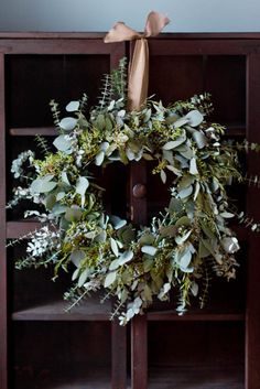 a wreath on top of a book shelf