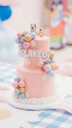 there is a pink cake with two small birds on top and the words blakley spelled out