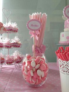 a table topped with lots of pink and white candy