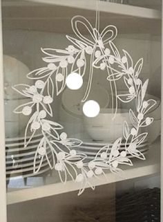 an image of a wreath on the glass in front of some plates and bowls,