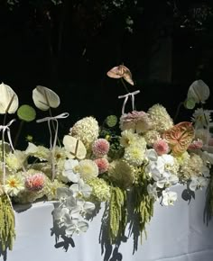 a table topped with lots of white and pink flowers