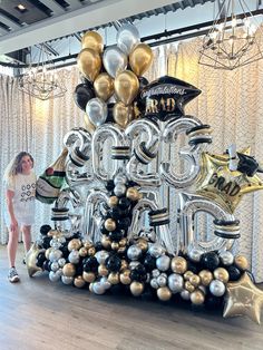 a woman standing in front of a large balloon shaped table with the number twenty five on it