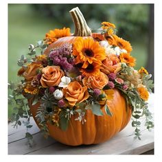 a pumpkin decorated with flowers and greenery