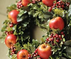 a wreath with apples and berries on it