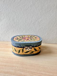 a blue and yellow box sitting on top of a wooden table next to a white wall