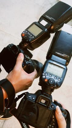 a person is holding two cameras and taking pictures