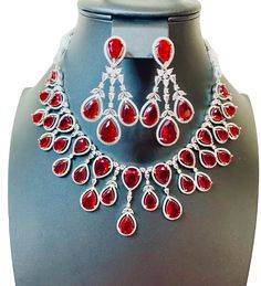 Enhance your jewelry collection with our CZ American Diamond and Red Stone Necklace set. This elegant set is perfect for any party or special occasion. The combination of CZ diamonds and red stones adds a touch of sophistication and glamour. Up your style game and stand out from the crowd with this stunning necklace set. Jewellery Care- Keep the jewellery dry, avoid contact with perfumes and water. Ruby Necklaces With Sparkling Stones For Party, Party Ruby Necklaces With Sparkling Stones, Party Ruby Necklace With Sparkling Stones, Elegant Ruby Jewelry Sets For Party, Dazzling Ruby Necklace For Party, Luxury Red Jewelry With Sparkling Stones, Luxury Red Rhinestone Jewelry, Dazzling Red Necklaces With Sparkling Stones, Red Ruby Jewelry Sets For Party