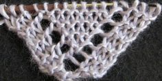 a close up of a crocheted piece of cloth with a knitting needle in it