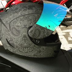 a motorcycle helmet sitting on the seat of a motorbike with a blue visor