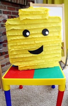 a chair made out of lego blocks with a smiling face on it's back