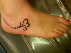 a woman's foot with a heart tattoo on it