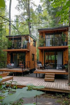 two tiny houses in the woods with wooden decking and stairs leading up to them