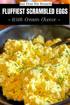 scrambled eggs with cream cheese in a black bowl on a wooden table and text overlay reads, but first we brunch fluffest scrambled eggs with cream cheese