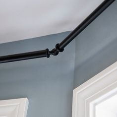 a black pipe is hanging from the ceiling in a room with blue walls and white trim