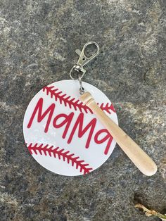 a baseball keychain with the word mom written on it and a wooden bat