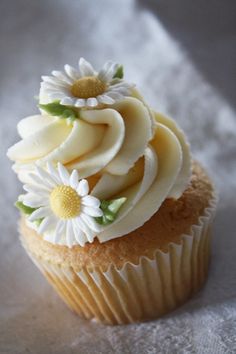 a cupcake with white frosting and flowers on top